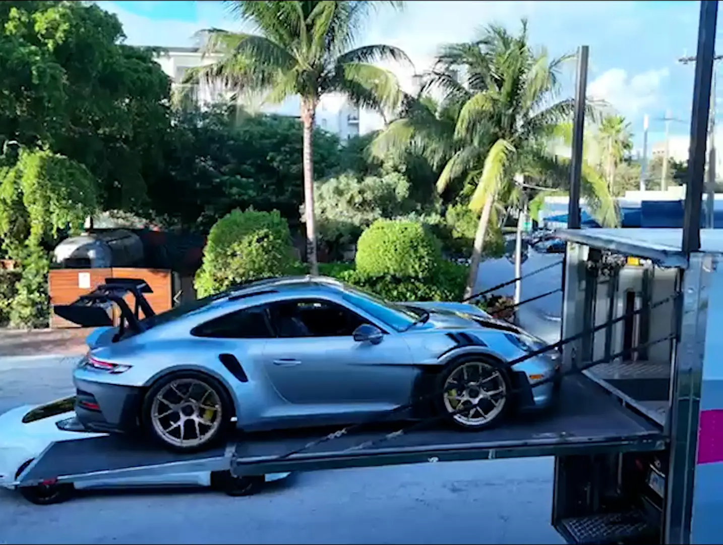 Silver Porsche unloading on liftgate at Portfolio Automotive Group